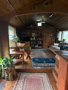 a living room filled with lots of furniture and rugs on top of wooden floors