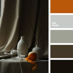 an orange and white vase sitting on top of a table next to a curtained window