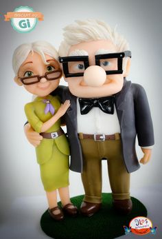 an old man and woman figurine with glasses on top of a green base