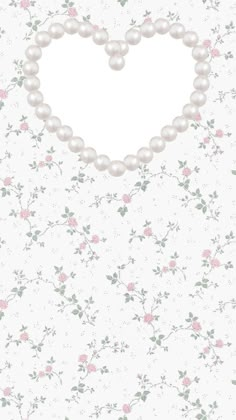 a heart shaped frame with pearls and flowers on a white wallpapered background photo