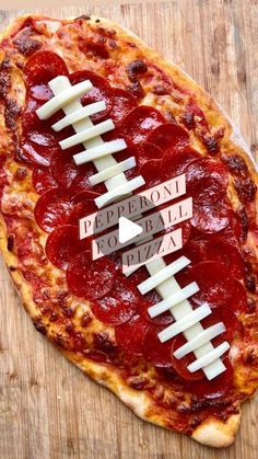 a pizza with a football on it sitting on top of a wooden cutting board