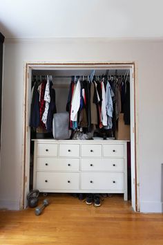 an open closet with clothes and shoes on the floor