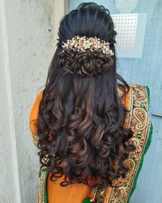 the back of a woman's head with long hair and flowers in her hair