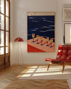 a red chair sitting in front of a painting on the wall next to a window