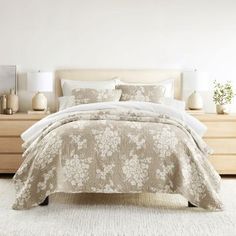 a bed with white sheets and pillows in a bedroom next to a dresser filled with vases