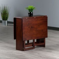 a small wooden table with a plant on top