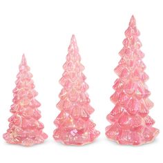 three pink plastic christmas trees sitting next to each other