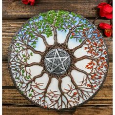 a glass plate with a pentagramil on it and some red flowers in the background