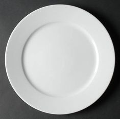 an empty white plate on a black surface