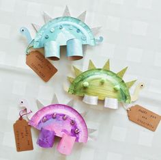 three paper dinosaurs with tags attached to them