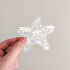 a hand holding a sticker with a starfish on it