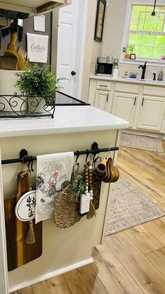 a kitchen island with pots and pans hanging from it's hooks on the wall