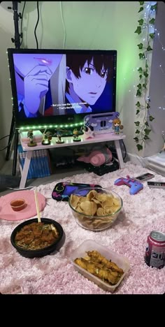 a table topped with plates of food next to a flat screen tv