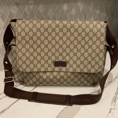 a beige and brown bag sitting on top of a counter next to a white tile wall