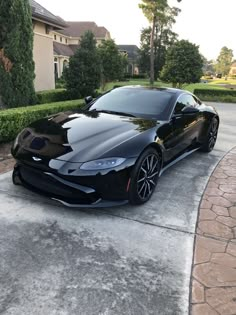 a black sports car parked in front of a house