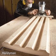 a man with headphones on working on a piece of wood that is being sanded