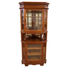 an antique wooden display cabinet with glass doors and drawers on the front, side view