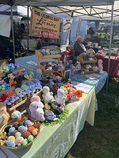 there are many stuffed animals on display at this outdoor vendor's market stall that sells them