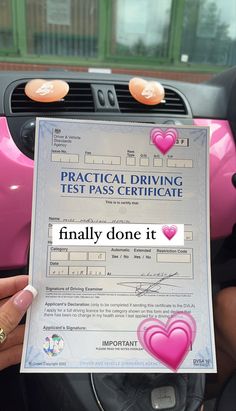 a person holding up a driving test pass in their hand with hearts on the front