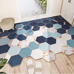 a pair of shoes sitting on the floor in front of a tiled entrance way with blue and white hexagonal tiles