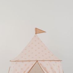 a pink tent with white polka dots and a wooden arrow sticking out of the top