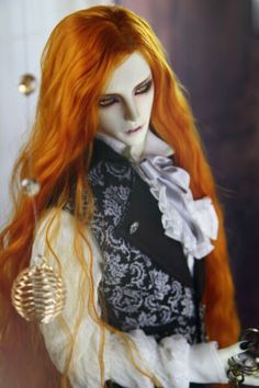 an orange haired doll dressed in black and white