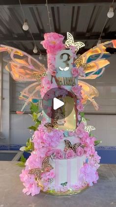 a cake decorated with pink flowers and butterflies