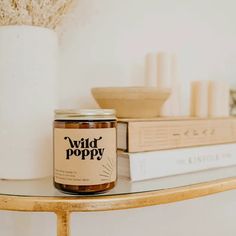 a jar of honey sitting on top of a table next to books and a vase