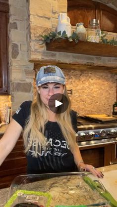 a woman standing in front of a pan filled with food