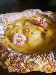 a pastry with powdered sugar and flowers on top