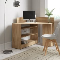 a desk with a computer on it and a chair next to it in front of a window