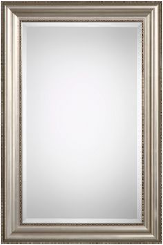 a silver framed mirror on a white wall with an ornate border around the frame and bottom edge