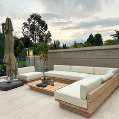 an outdoor living area with couches, tables and umbrellas on the roof terrace