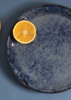 an orange sitting on top of a blue plate