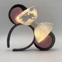 a minnie mouse head with a white bow on it's side and light up ears