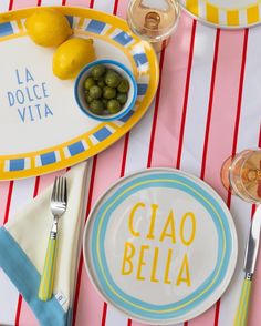 a table set with plates, silverware and lemons