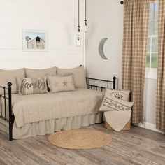 a day bed sitting in a bedroom on top of a hard wood floor next to a window