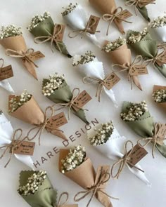 there are many small cones with flowers in them on the white tablecloth and tied together