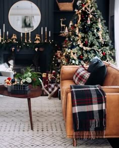 a living room decorated for christmas with a couch, coffee table and tree in the background