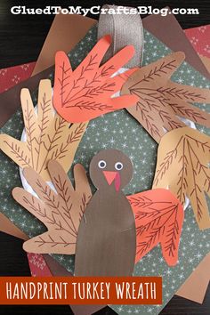 a turkey made out of paper on top of a table with the words handprint turkey wreath