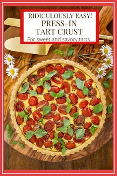 a tart crust with tomatoes, cheese and basil on it in front of a cutting board