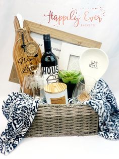 a basket filled with wine and other items on top of a white table next to a sign that says happily ever