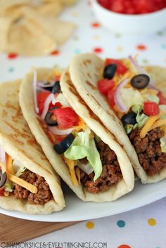 three tacos sitting on top of a white plate