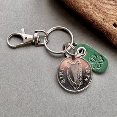 a close up of a coin on a keychain with a shamrock charm attached to it