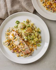 two white plates filled with food on top of a table