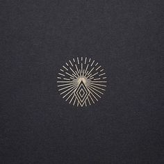 a black background with gold lines and a sunburst in the middle on it