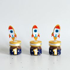 three small jars with peanut butter and an image of a rocket ship on one jar