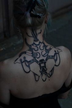 the back of a woman's neck with tattoos on it