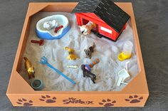 a sandbox filled with toys on top of a table