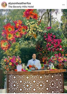 a man sitting at a bar with flowers in the background